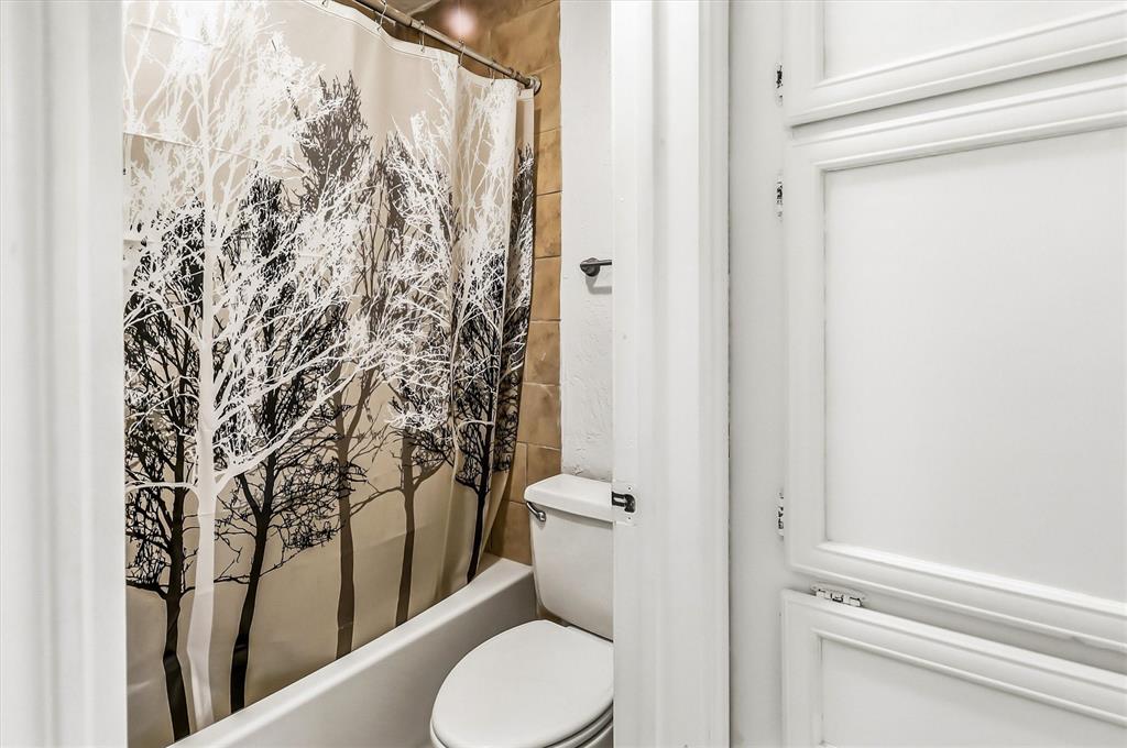 15151 Berry Trail, Unit 1307 Dallas, TX 75248 - Photo 21 of 27 Bathroom with shower / bath combo with shower curtain and toilet