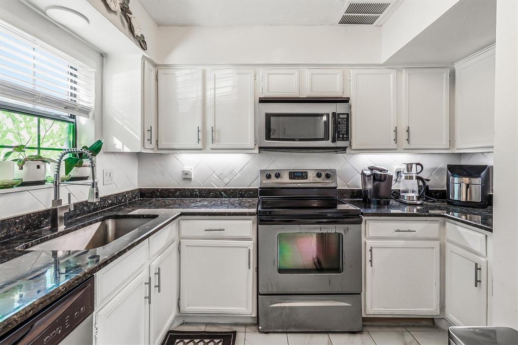 15151 Berry Trail, Unit 1307 Dallas, TX 75248 - Photo 10 of 27 Kitchen with stainless steel appliances, backsplash, and white cabinets