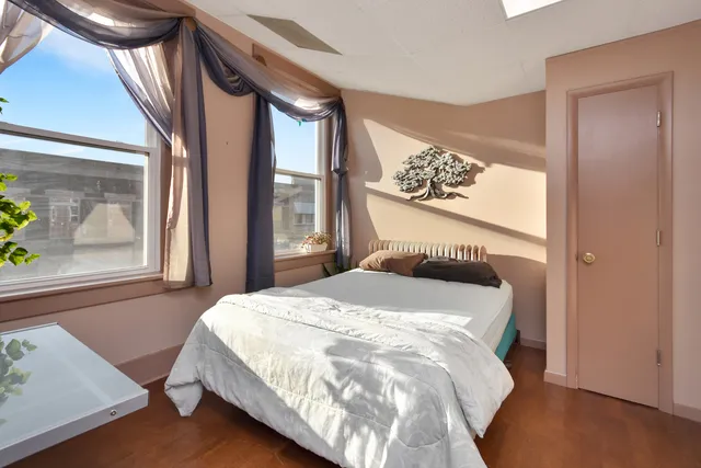 a bedroom with a bed and a view of chandelier