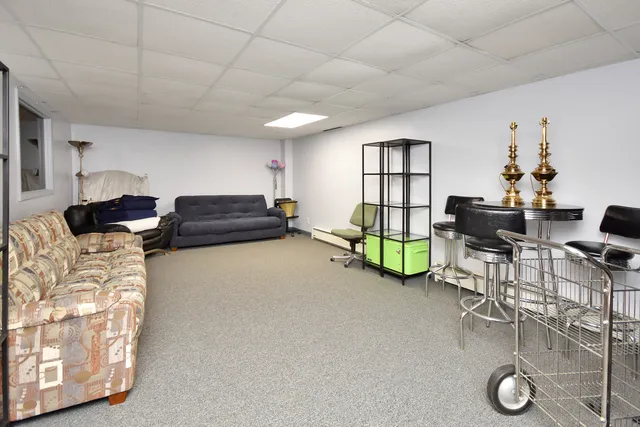 a living room with furniture and a refrigerator