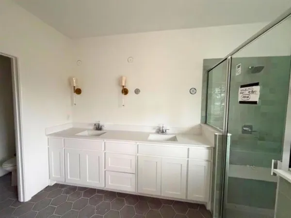 a bathroom with a sink a toilet and shower