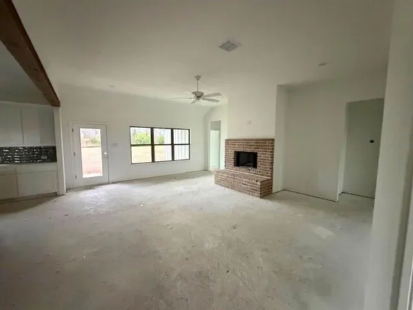 a view of a livingroom with a fireplace and window