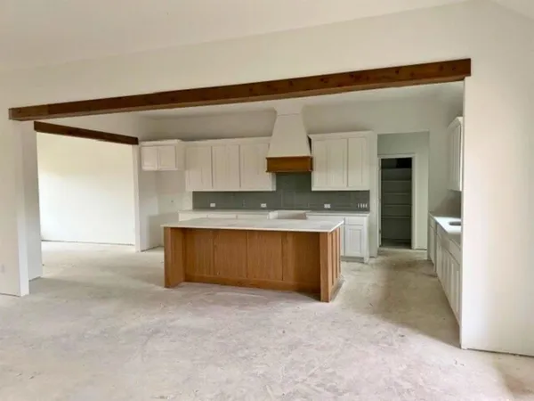 a large kitchen with kitchen island granite countertop a large window and a sink