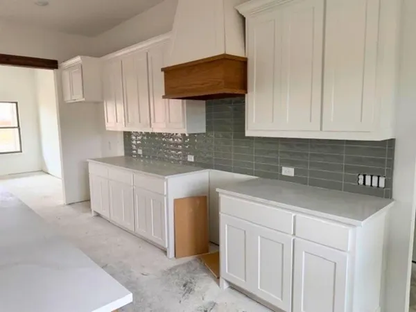 a kitchen with granite countertop a sink a stove and cabinets