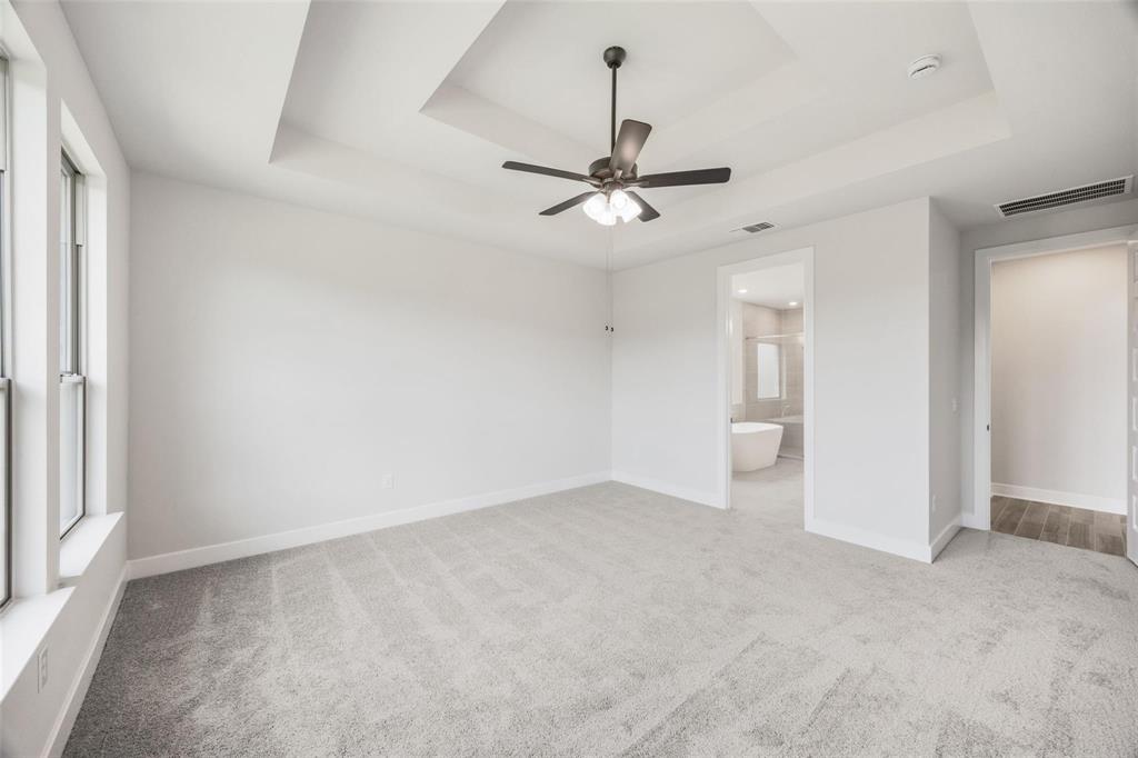 504 Sundance Ridge Georgetown, TX 78628 - Photo 10 of 34 Plush carpeting and a tiered tray ceiling define this elegant main bedroom suite.