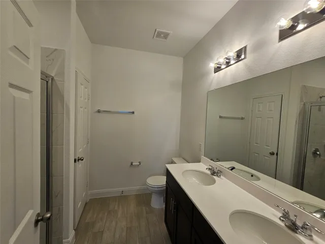 a bathroom with a sink a toilet and shower