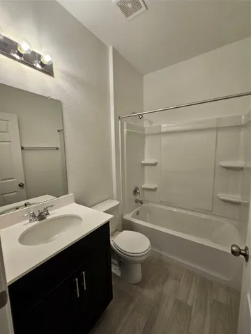 a bathroom with a sink vanity mirror and toilet
