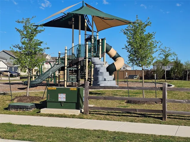 a view of a yard in front of a house with a large tree