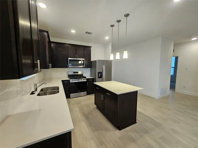 a kitchen with stainless steel appliances a refrigerator and a stove top oven