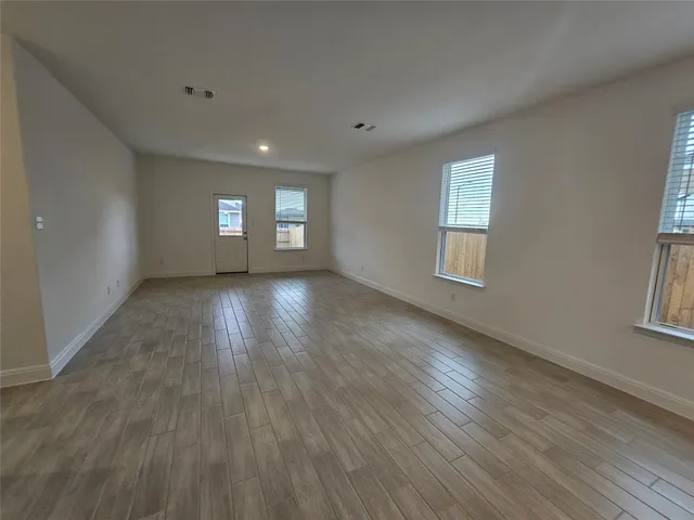 a view of a room with wooden floor and windows