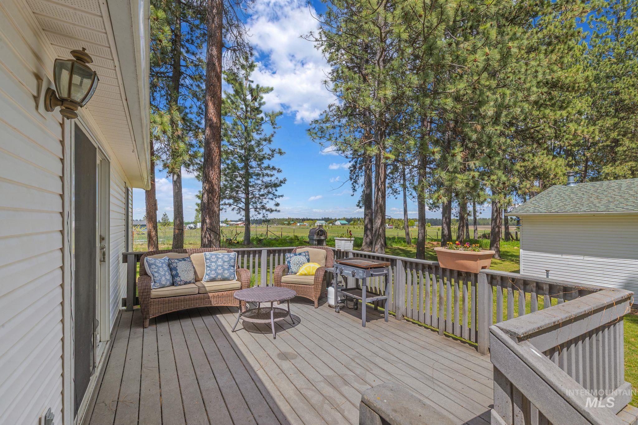 1820 Winchester Road Winchester, ID 83555 - Photo 31 of 50 Expansive deck featuring wood decking and railings, white siding, and an outdoor wall sconce