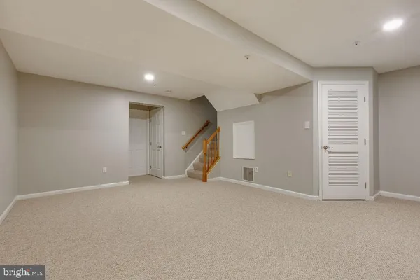 an empty room with a staircase and a ceiling fan