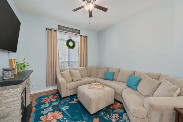 a living room with furniture a flat screen tv and a rug