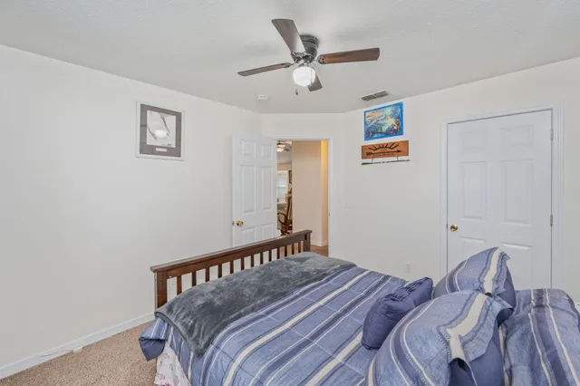 a bedroom with a bed and a ceiling fan