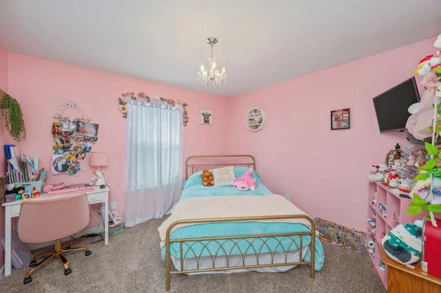 a bedroom with a bed mirror and a window