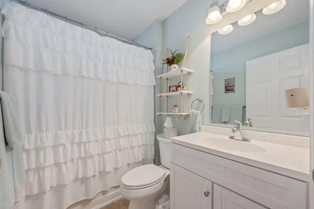 a bathroom with a sink a toilet and shower curtain