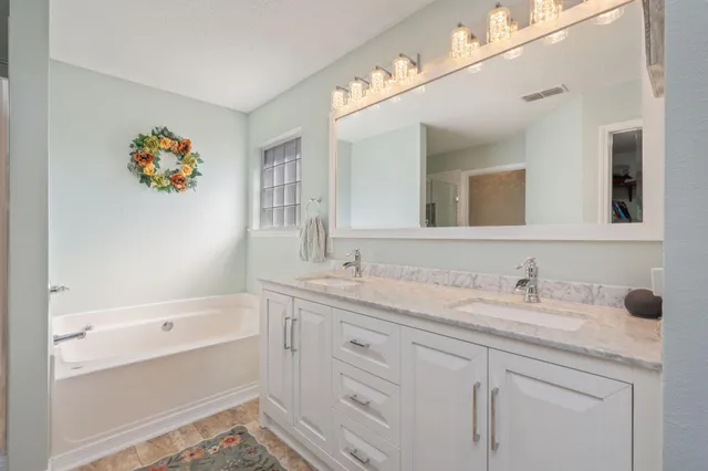 a bathroom with a tub sink and mirror