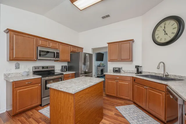 a kitchen with stainless steel appliances granite countertop a stove top oven a sink dishwasher and a microwave oven with cabinets