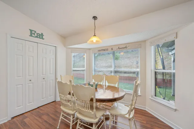 a dining room with furniture a chandelier and wooden floor