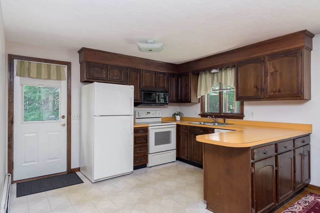 35 Juniper Lane Rutland, MA 01543 - Photo 2 of 15 a kitchen with refrigerator a sink and dishwasher with wooden cabinets