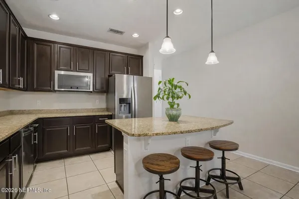 a kitchen with a stove a sink and chandelier