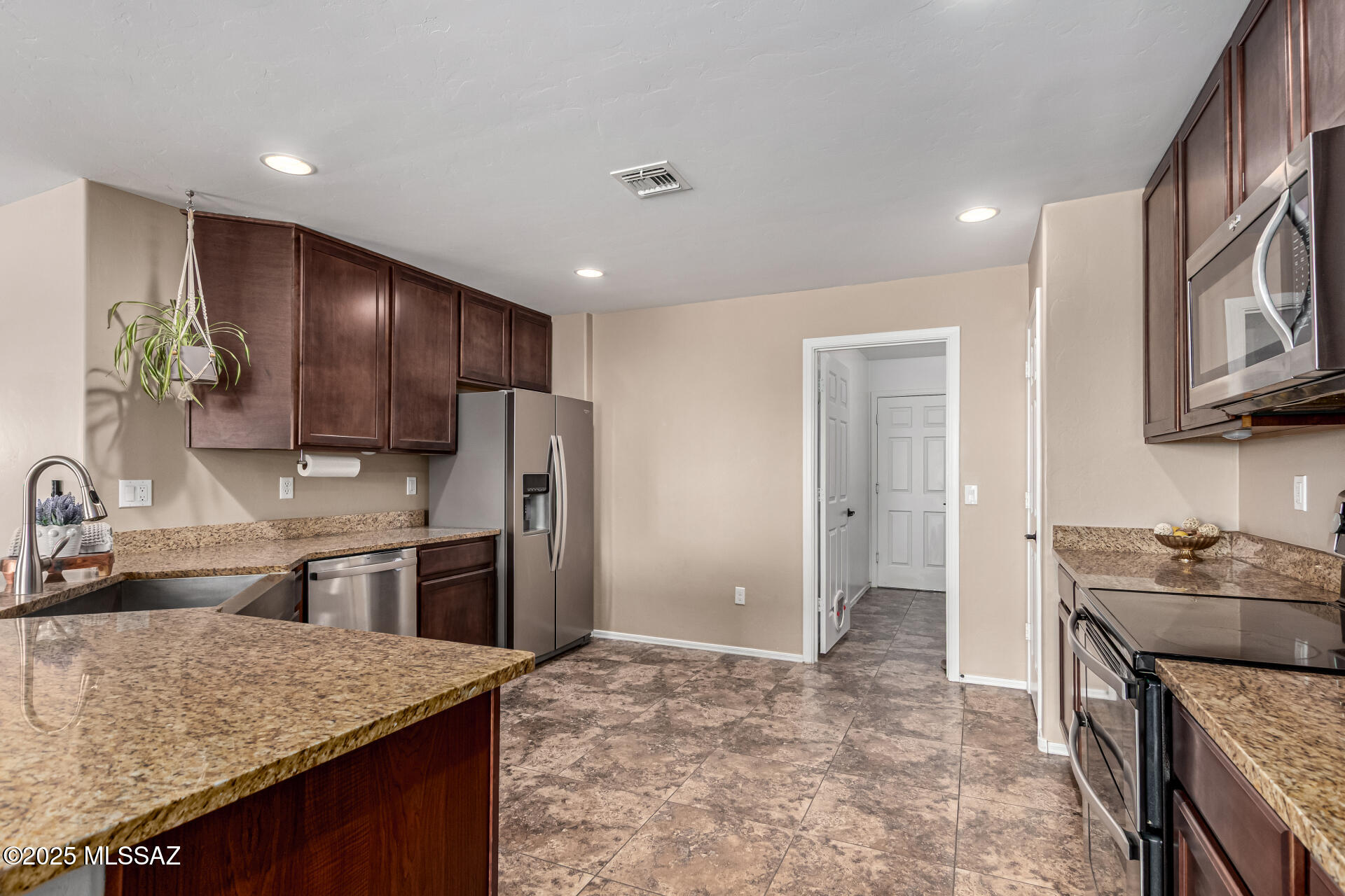 9528 Desert Fauna Loop Tucson, AZ 85747 - Photo 13 of 46 a kitchen with stainless steel appliances granite countertop a sink stove and refrigerator