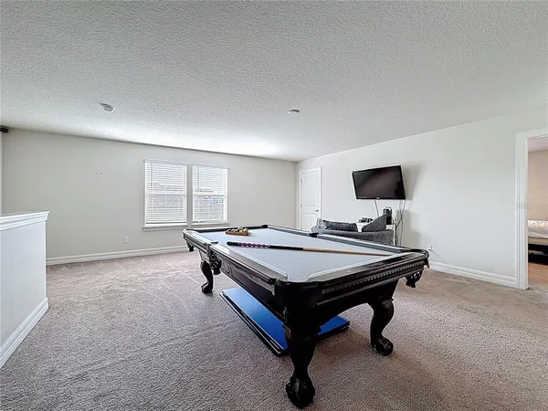 a room with pool table and windows