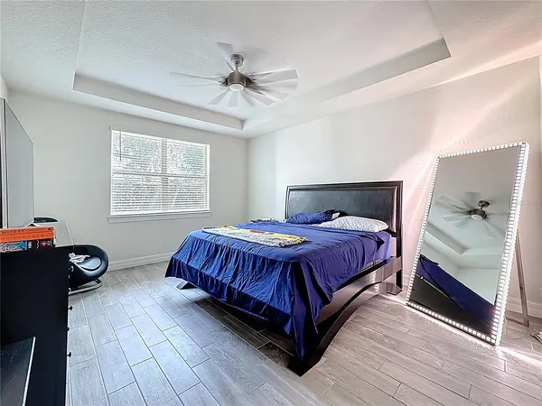 a spacious bedroom with a bed and wooden floor