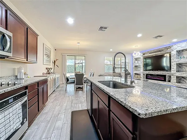 a kitchen with stainless steel appliances granite countertop a sink stove and cabinets