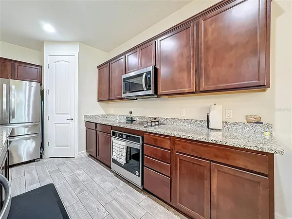 a kitchen with stainless steel appliances granite countertop a refrigerator microwave and sink