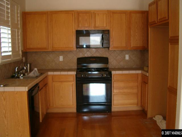 2180 Evergreen Reno, NV 89521 - Photo 2 of 9 a kitchen with granite countertop wood cabinets and a stove top oven