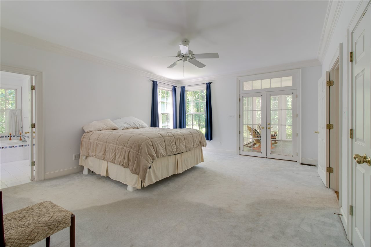 10 Pearse Wynd Road Bahama, NC 27503 - Photo 12 of 29 a bedroom with a large bed chandelier and a window