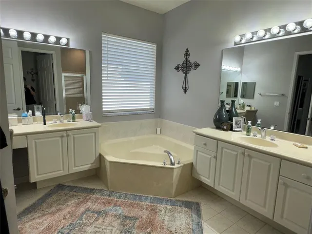 a bathroom with a tub sink and mirror