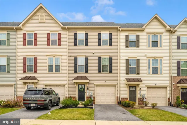 a view of a house with a yard and car parked