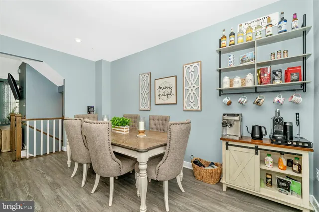 a view of a dining room with furniture a rug and wooden floor