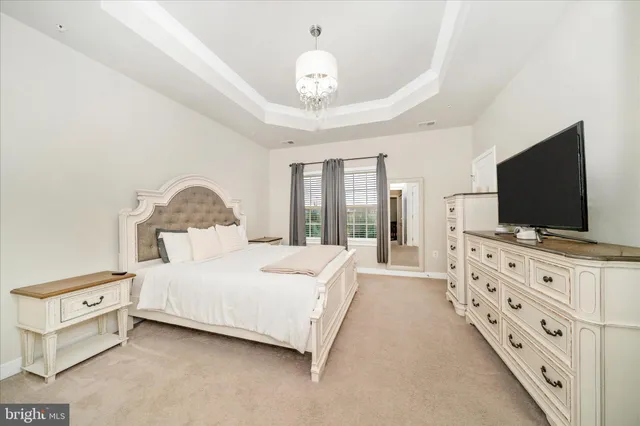 a bedroom with a large bed and a flat tv screen on dresser