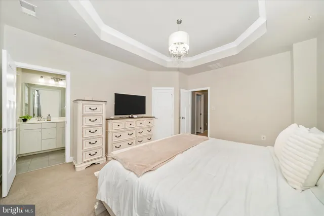 a spacious bedroom with a bed and a flat screen tv