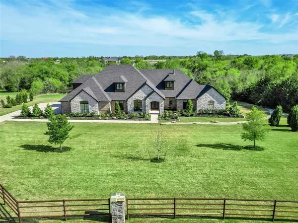an aerial view of a house with a big yard
