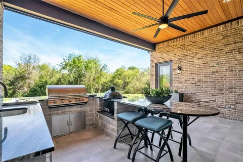 an aerial view of residential house with outdoor space and trees all around
