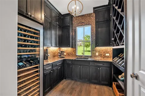 a kitchen with kitchen island granite countertop a sink a center island a stove and cabinets