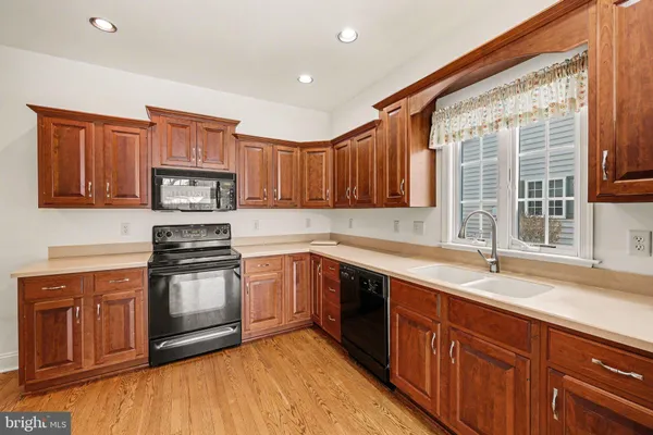 a kitchen with wooden cabinets a sink and a stove