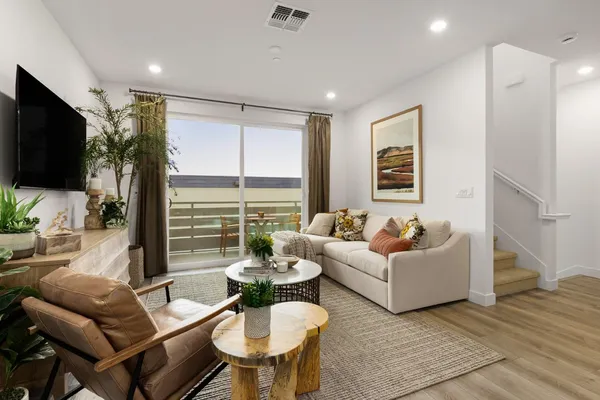 a living room with furniture a flat screen tv and a large window