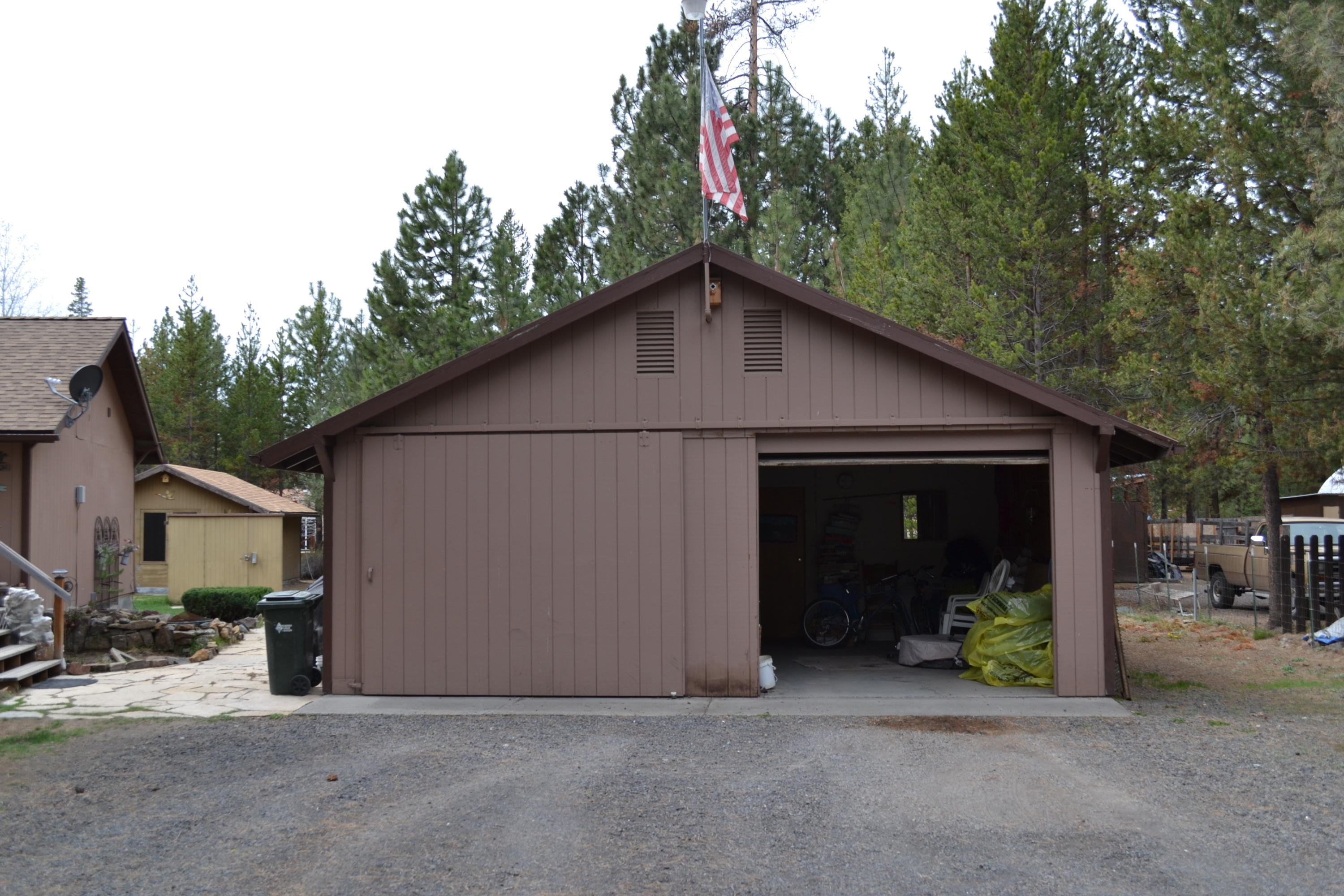 52729 Ammon Road La Pine, OR 97739 - Photo 3 of 29 a view of a house with a garage and large tree