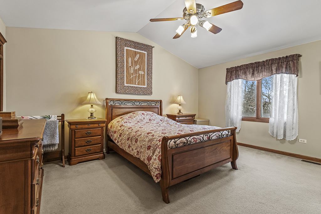 1011 Ranchwood Drive Shorewood, IL 60404 - Photo 9 of 18 a bedroom with a bed and a chandelier