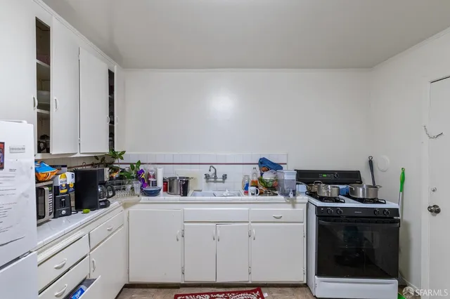 a kitchen with stainless steel appliances a refrigerator sink and white cabinets