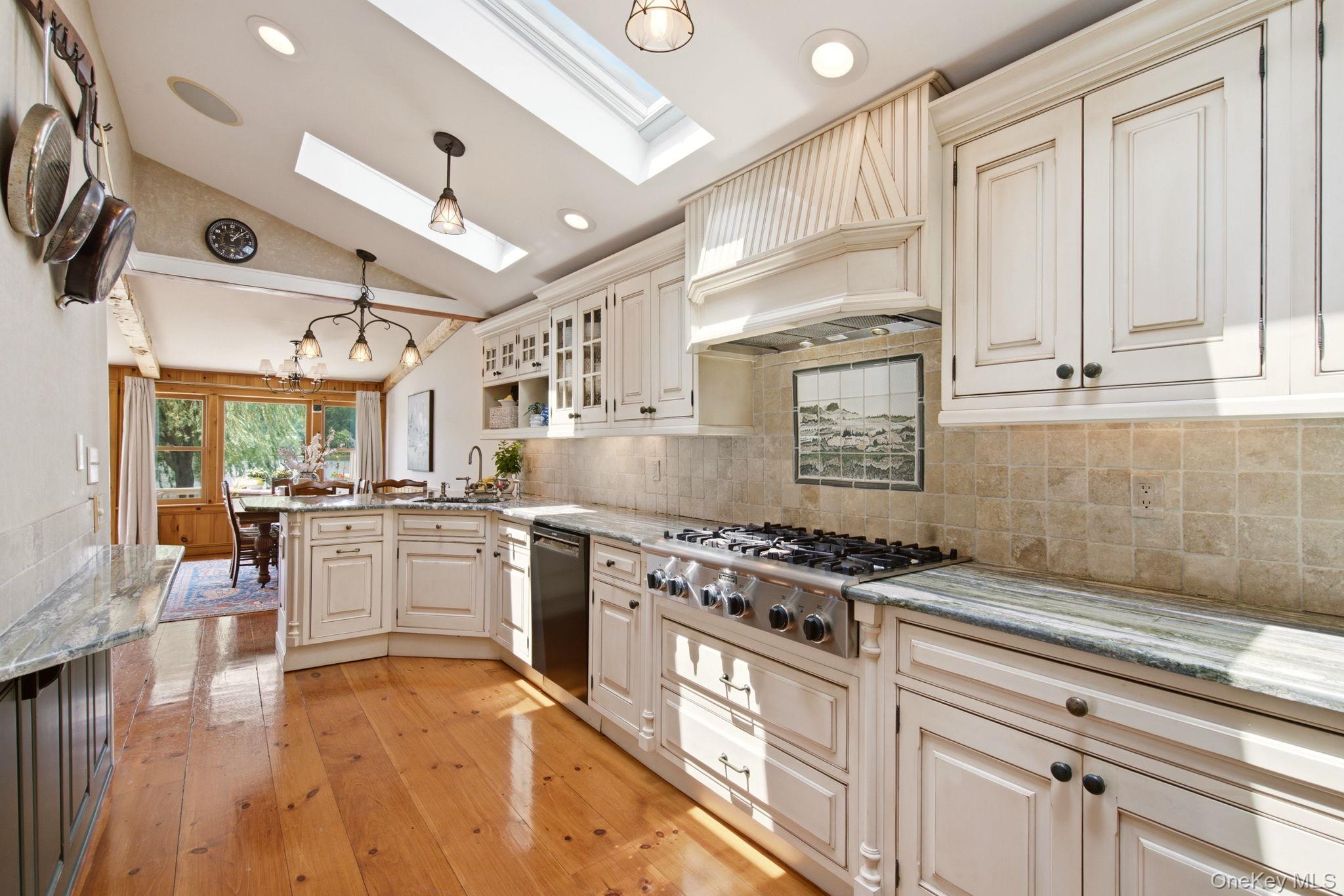 33 Prospect Road Centerport, NY 11721 - Photo 21 of 48 Stone backsplash with framed mural behind the Thermodore 6-burner gas range.