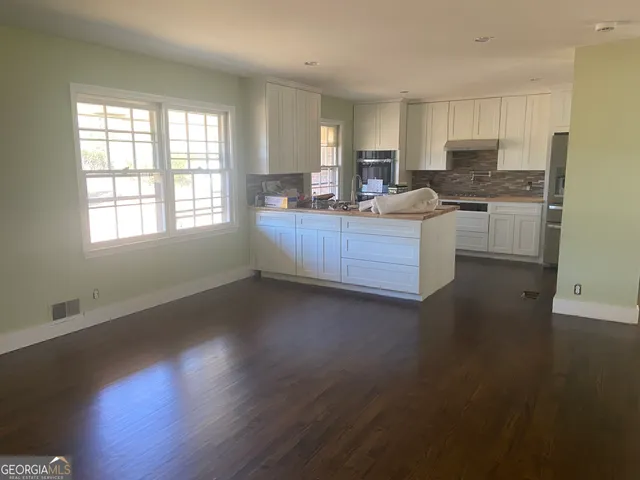 a kitchen with granite countertop wooden floors and white stainless steel appliances