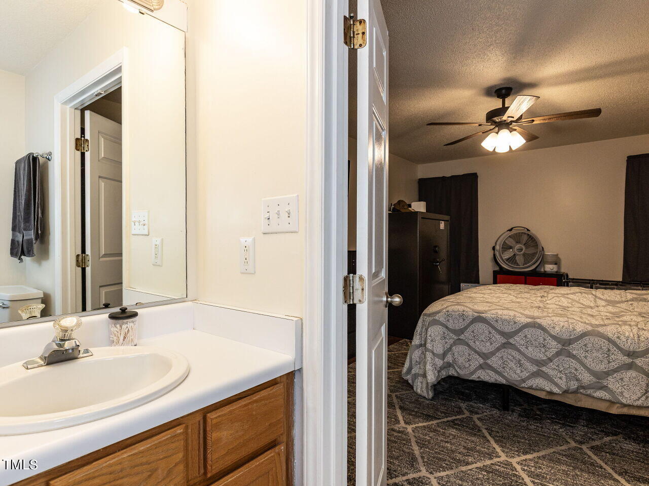 1955 Ranch Road Clayton, NC 27520 - Photo 16 of 28 a bedroom with a bed and a bathroom with mirror