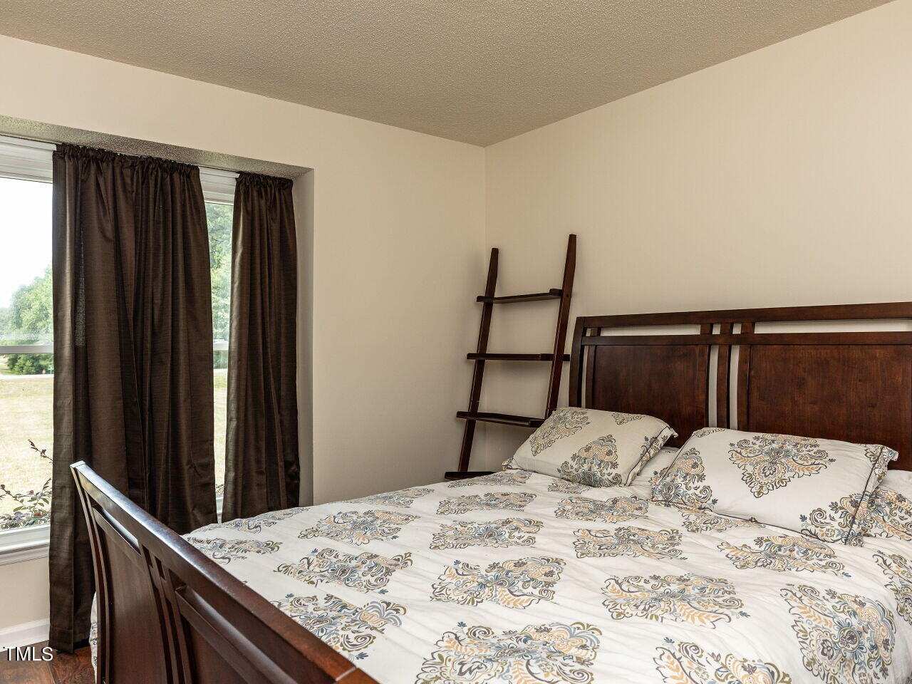 1955 Ranch Road Clayton, NC 27520 - Photo 17 of 28 a bed sitting in a bedroom next to a window