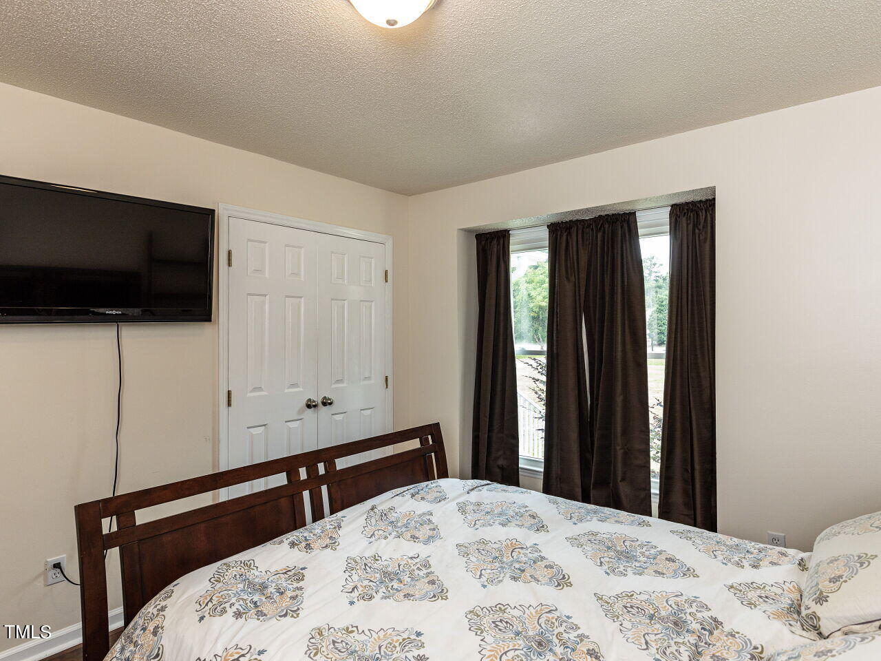 1955 Ranch Road Clayton, NC 27520 - Photo 19 of 28 a bedroom with a bed and a flat screen tv